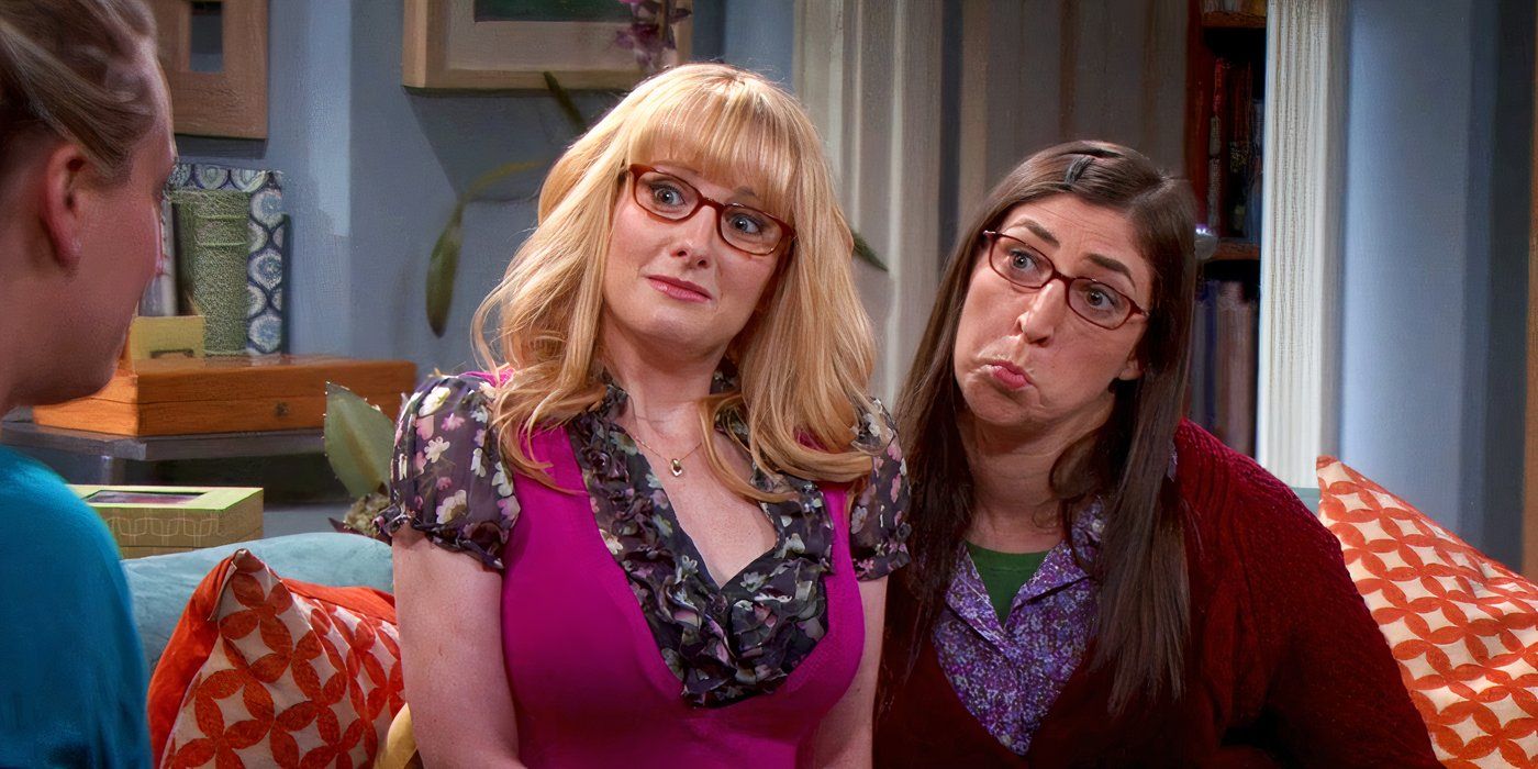 Melissa Rauch and Mayim Bialik as Bernadette and Amy, sitting on Penny's couch and making begging faces on The Big Bang Theory