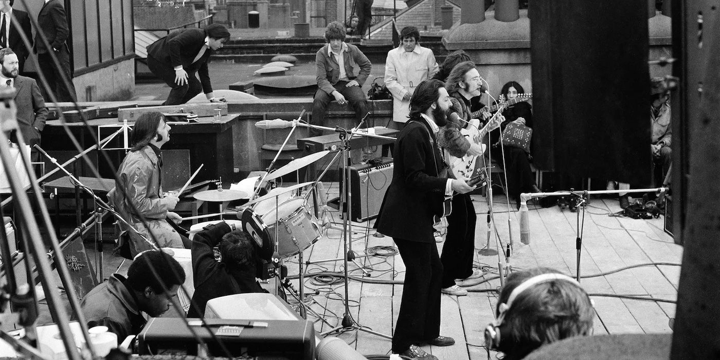 Black and white image of the Beatles playing their rooftop concert in 'Let It Be'