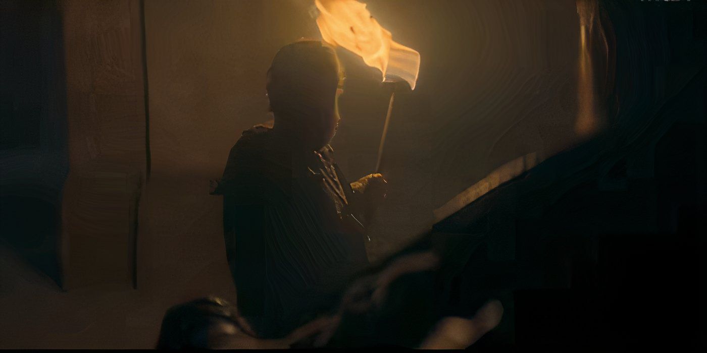 A figure holding a torch in House of the Dragon Season 2