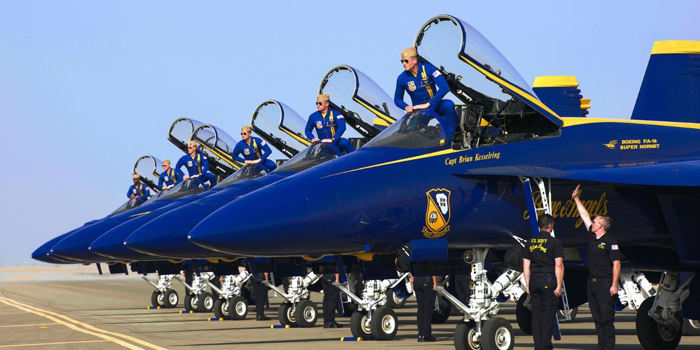 A group of Blue Angel jets on the runway with their pilots stepping into the cockpit.