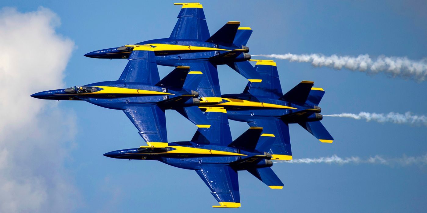 A quartet of Blue Angel jets flying in sync with one another.