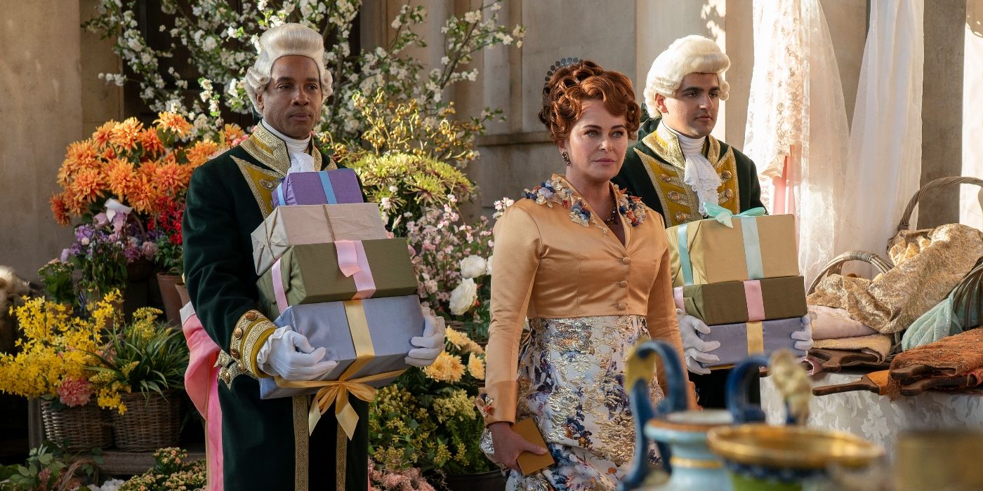 Polly Walker flanked by footmen holding boxes in Bridgerton Season 3