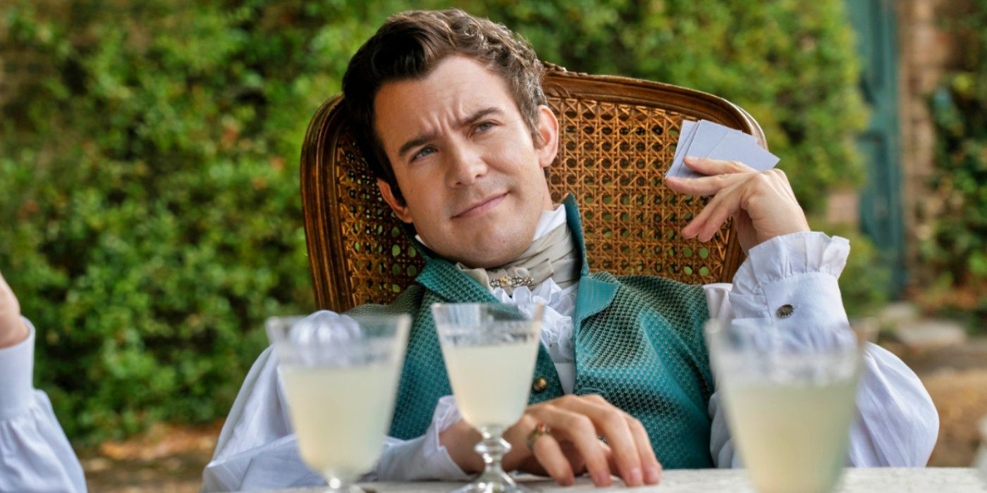 Luke Thompson as Benedict Bridgerton sitting at a table with cards and lemonade in Bridgerton Season 3