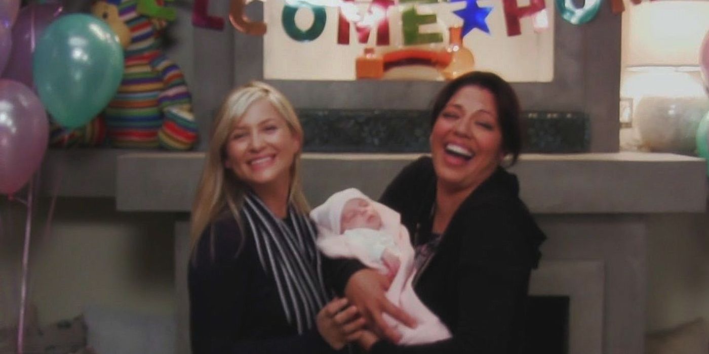 Callie and Arizona posing for a picture while holding their newborn daughter 