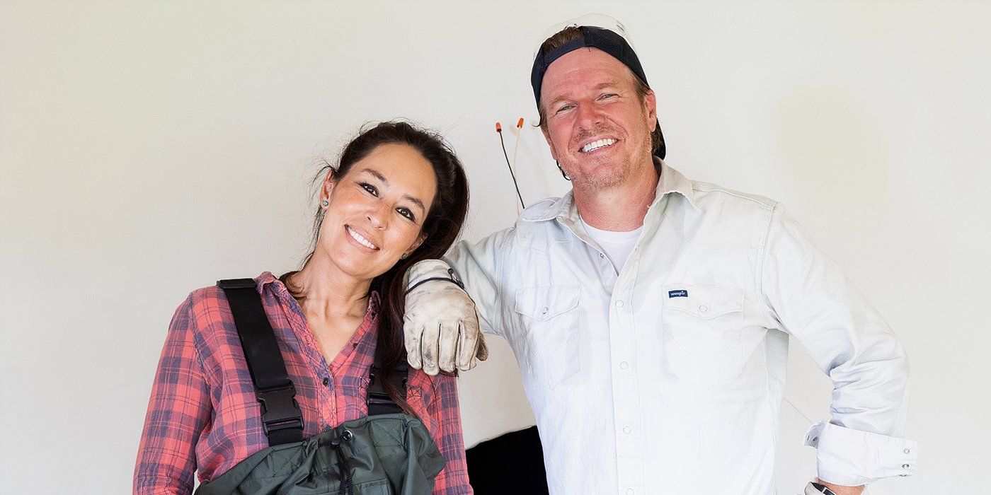 Joanna and Chip Gaines standing together in work gear in Fixer Upper: The Lakehouse