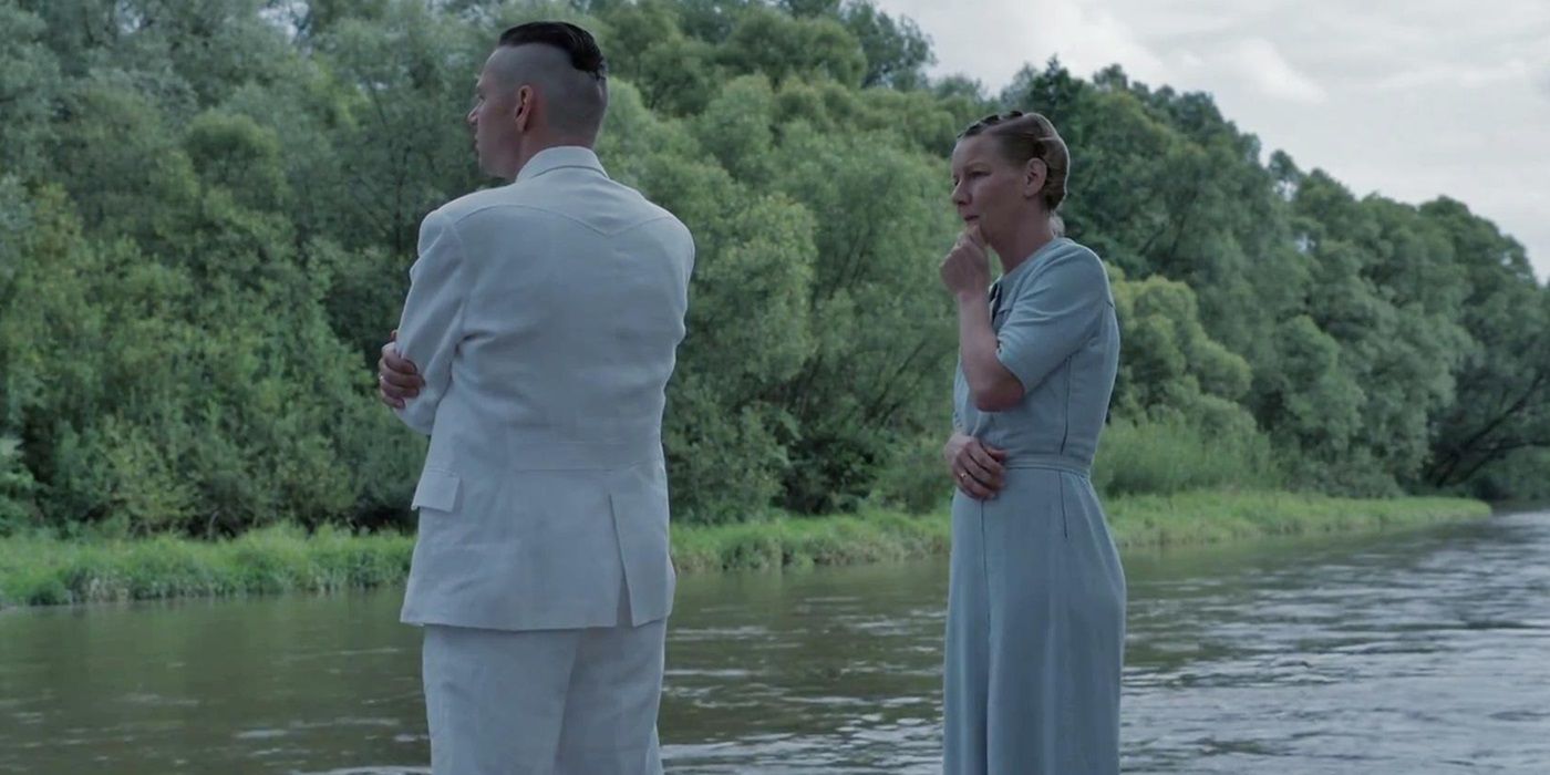 Rudolf Höss and Hedwig Höss standing by a river in The Zone of Interest