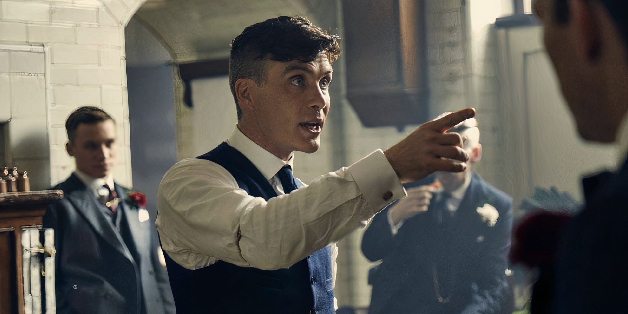 Cillian Murphy as Tommy Shelby pointing at a man in Peaky Blinders.