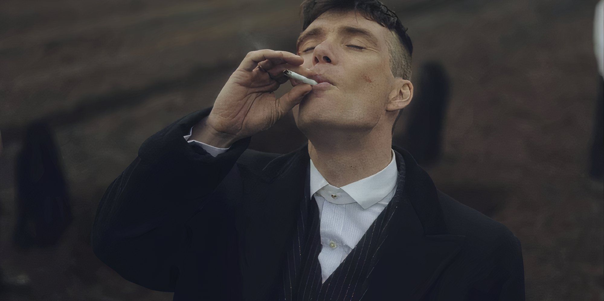 Cillian Murphy as Tommy Shelby smoking a cigarette in Peaky Blinders.