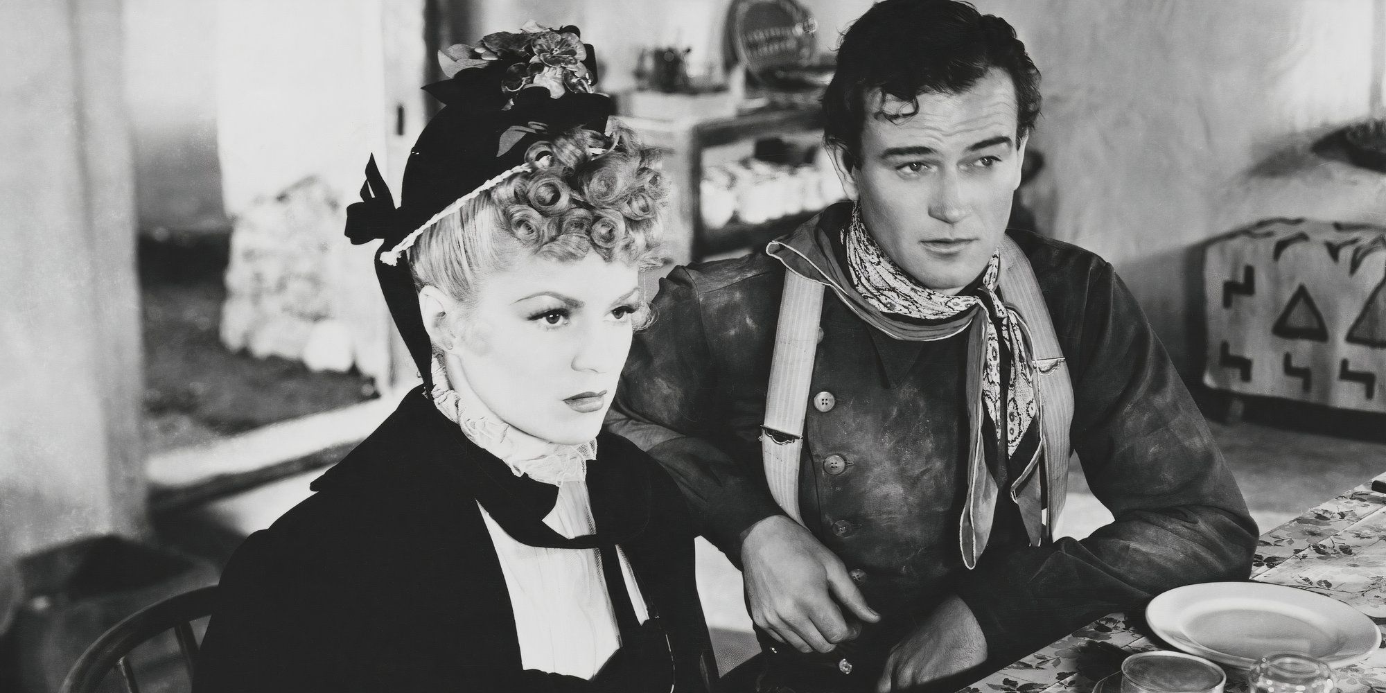 Claire Trevor and John Wayne in Stagecoach sitting next to each other