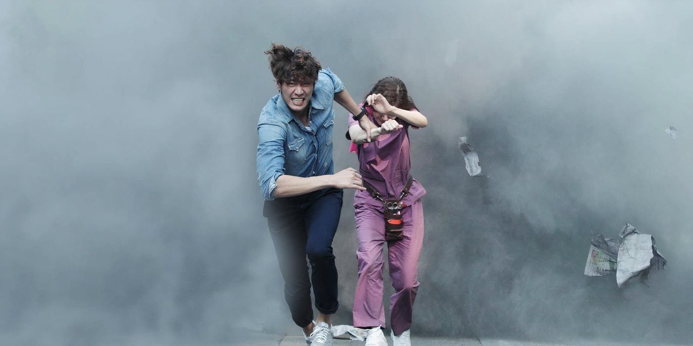 A man and woman run away from an explosion of a large cloud of thick, dark smoke in the K-drama D-Day.