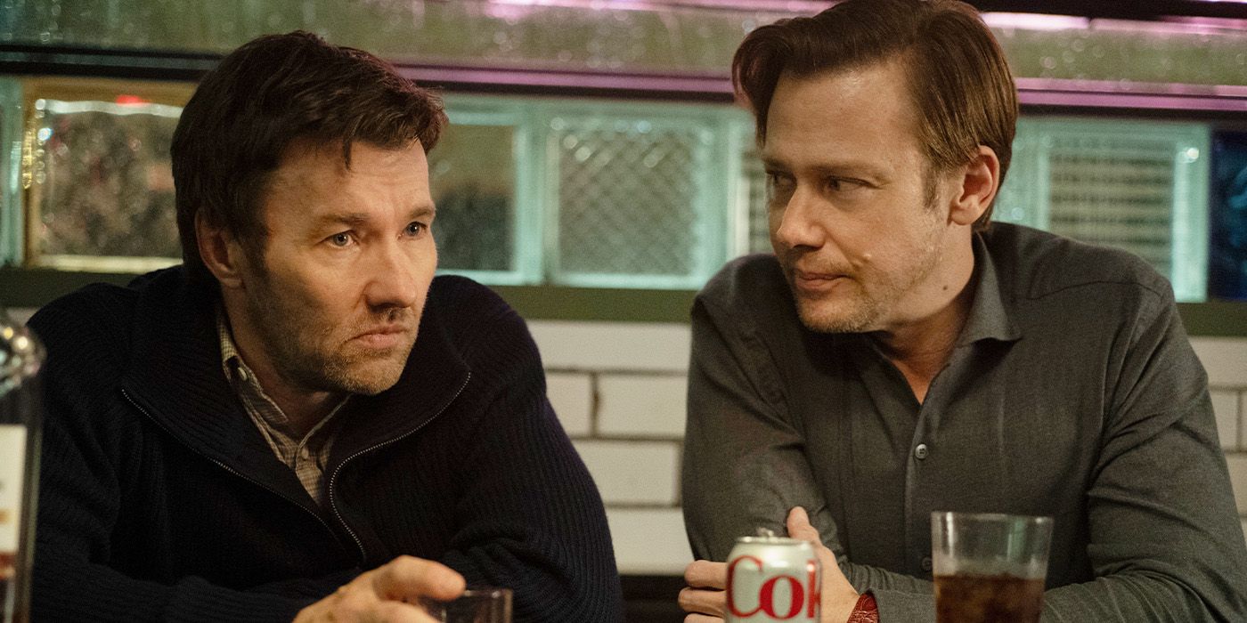 Joel Edgerton and Jimmie Simpson sit together at a bar with drinks, looking solemn