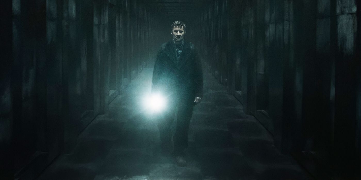 Joel Edgerton as Jason Dessen walking through an endless hallway holding a flashlight in Dark Matter.
