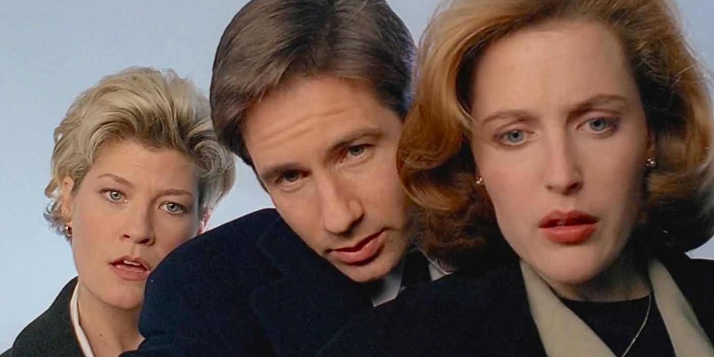 David Duchovny and Gillian Anderson investigate a crime scene with local police in a close up shot from episode Syzygy in The X-Files