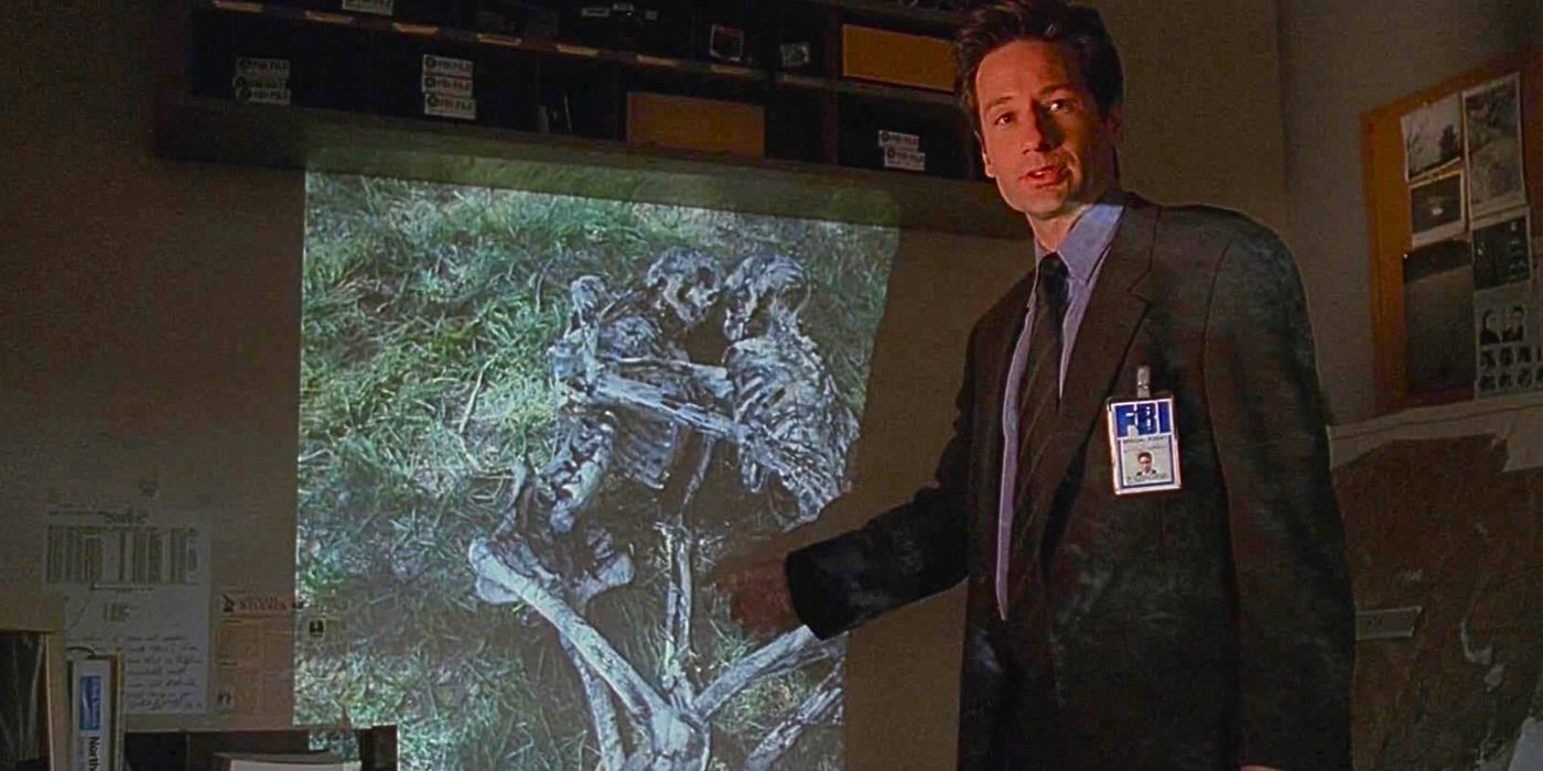 David Duchovny reviews a case file as he points to skeletal remains in a slideshow from episode Field Trip in The X-Files