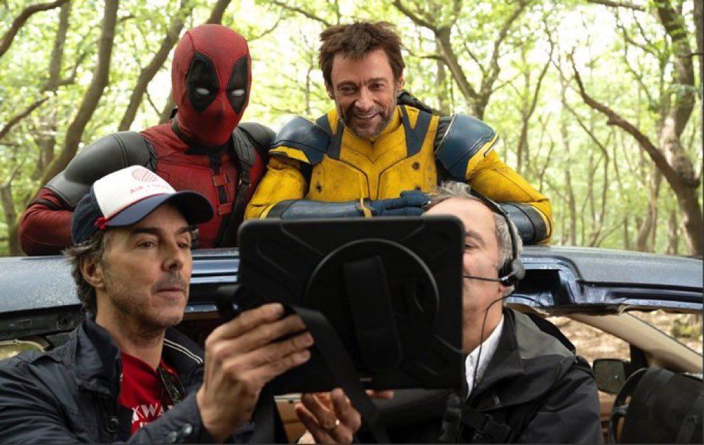 Shaun Levy showing Hugh Jackman and Ryan Reynolds something on an iPad monitor on the set of Deadpool & Wolverine