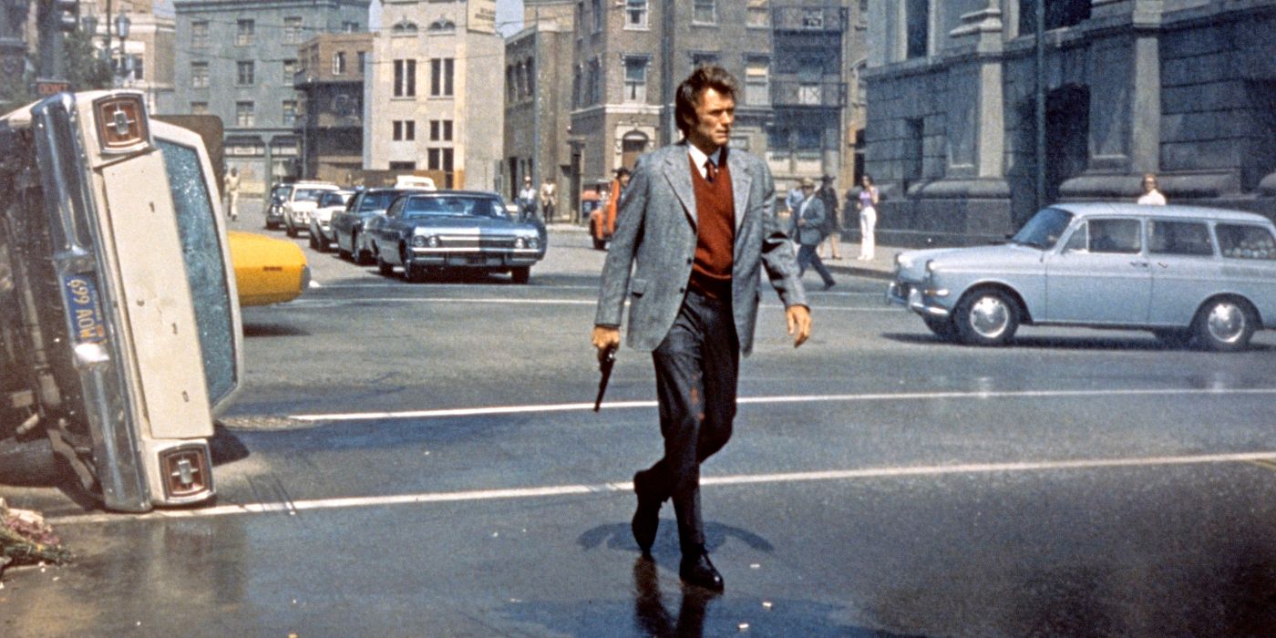 Clint Eastwood as Harry Callahan, holding a gun and walking through a street next to an overturned car in Dirty Harry