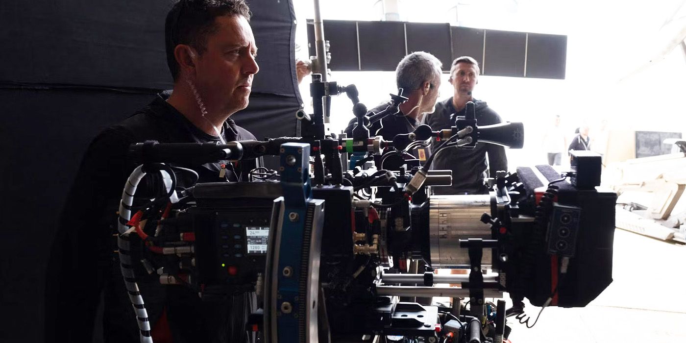 Greig Fraser working a large camera and looking off to the side on the set of Dune