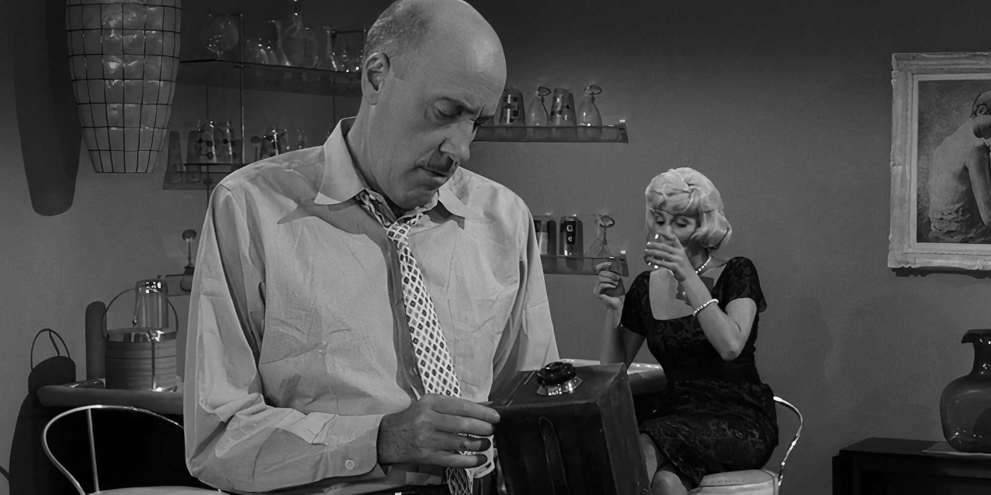 Fred Clark holding a camera while Joan Carson sits in the background with a drink in The Twilight Zone