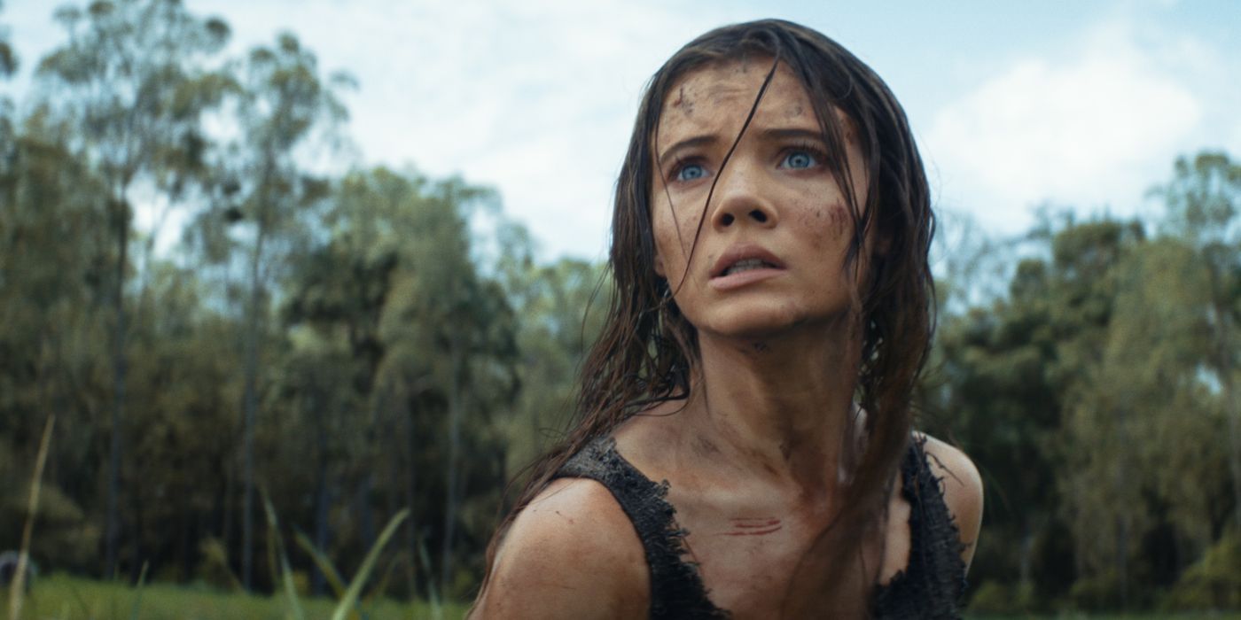 Freya Allan as Mae looking onward in terror, with mud and dirt on her face, in Kingdom of the Planet of the Apes