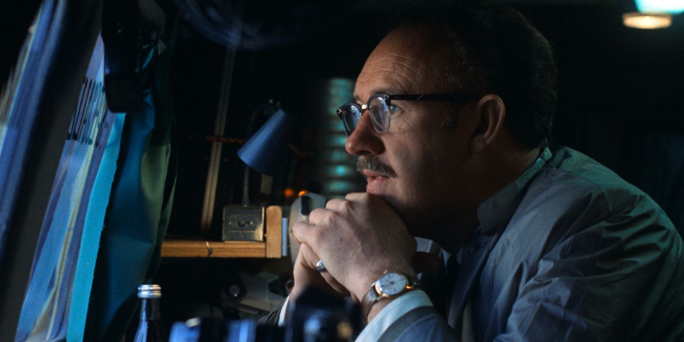 Gene Hackman in glasses looking at a screen, his chin resting on his hands in The Conversation