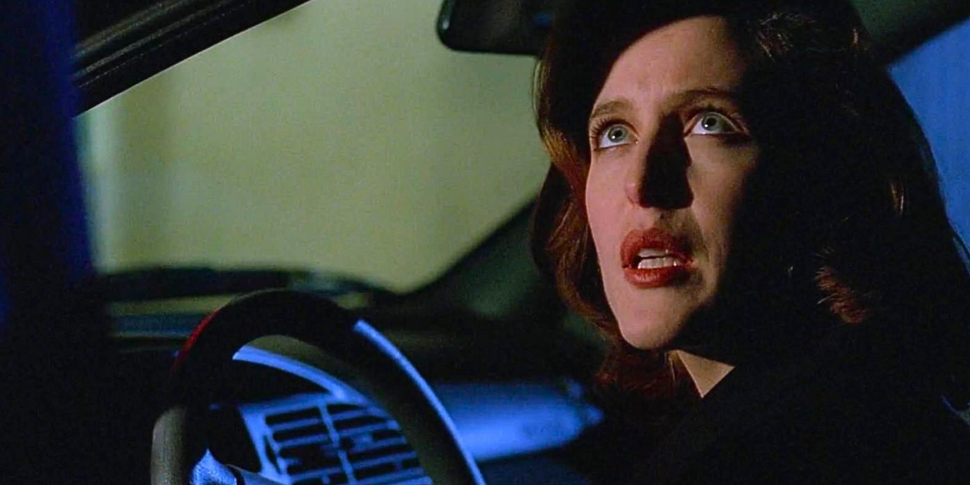 Gillian Anderson sits behind the wheel of a car as she looks up at Mulder from The X-Files