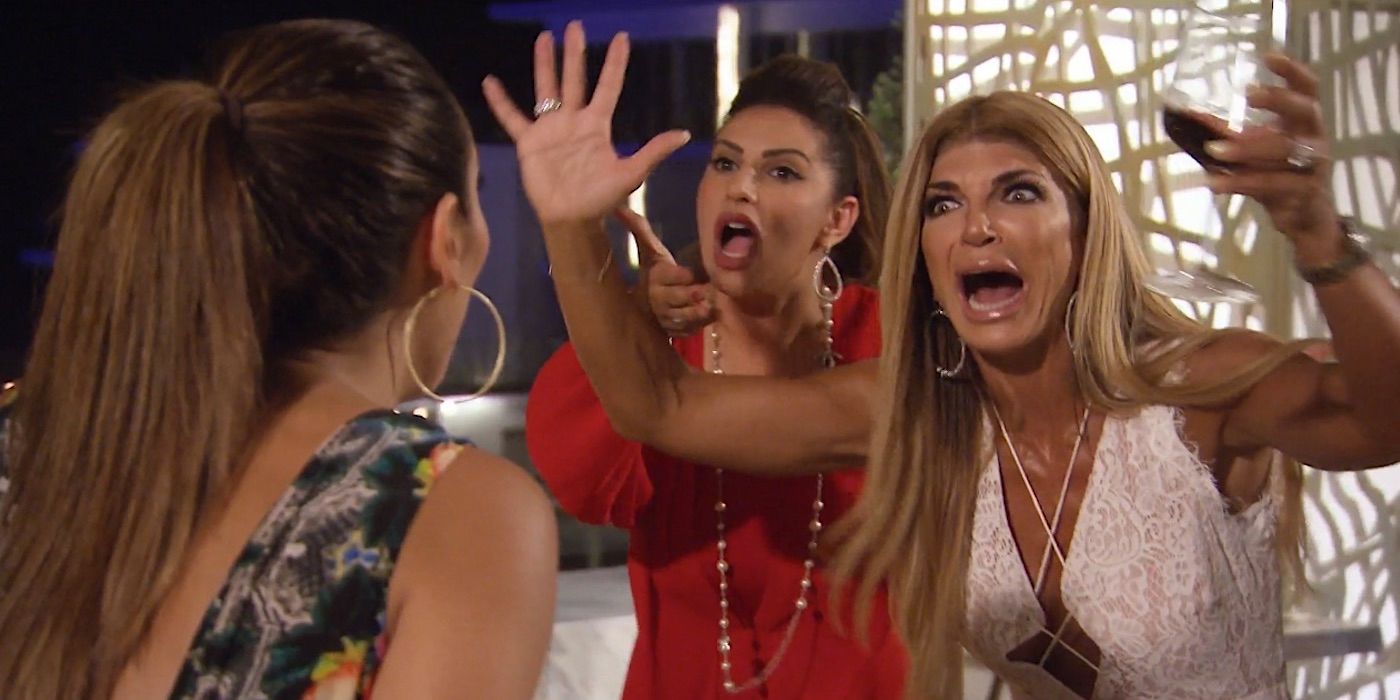 Teresa Giudice levanta las manos por encima de la cabeza, sostiene una copa de vino y le grita a Melissa Gorga.