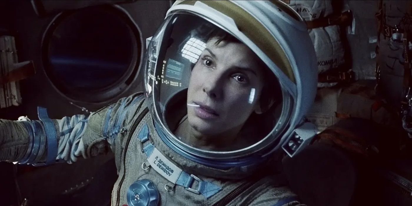 Sandra Bullock as Ryan Stone in her space-suit looking at an object offscreen in Gravity