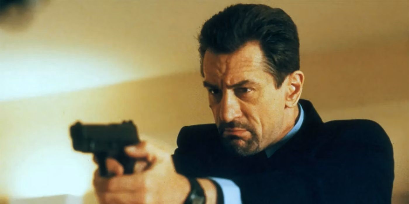 Robert De Niro as Neil McCauley point a gun at a taget off camera in 1995's Heat