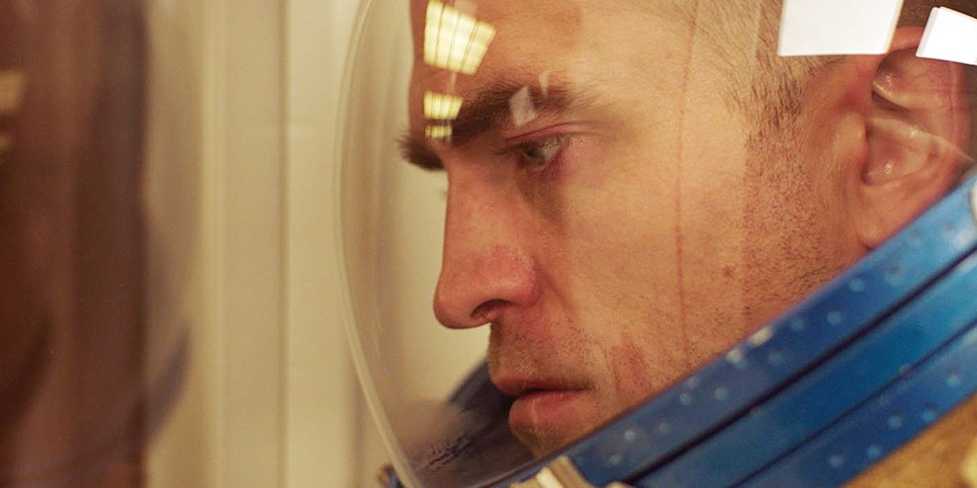 Monte (Robert Pattinson) in his space suit, looking at an object offscreen, in High Life