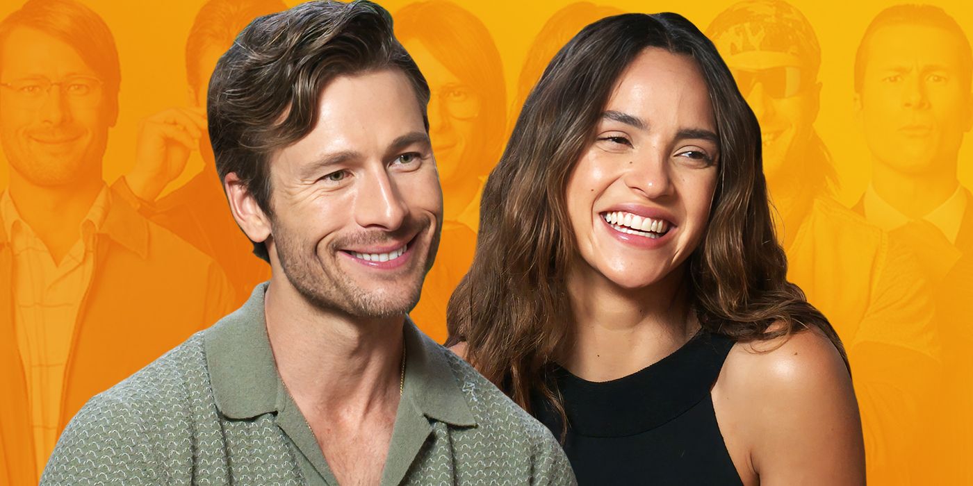Glen Powell and Adria Arjona smile during an interview for Hit Man with orange background