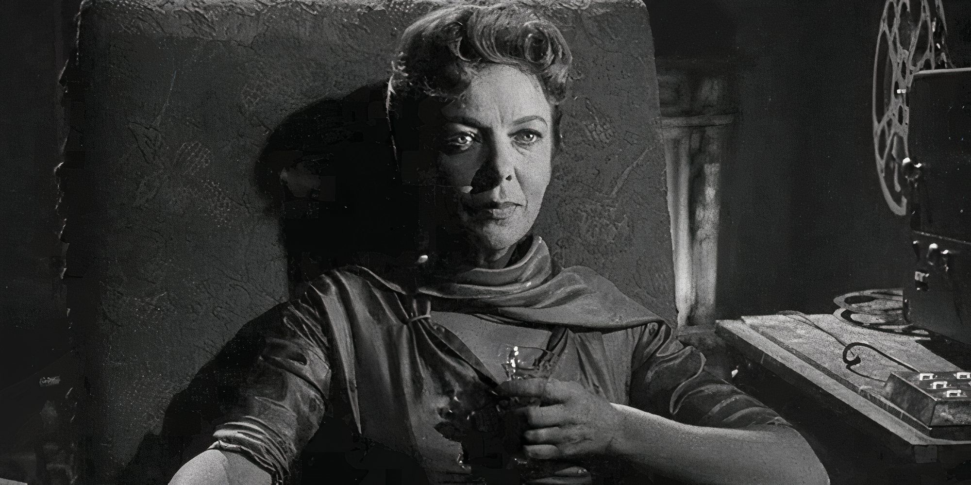 Ida Lupino sitting in a chair with a drink in her hand in The Twilight Zone episode The Sixteen-Millimeter Shrine