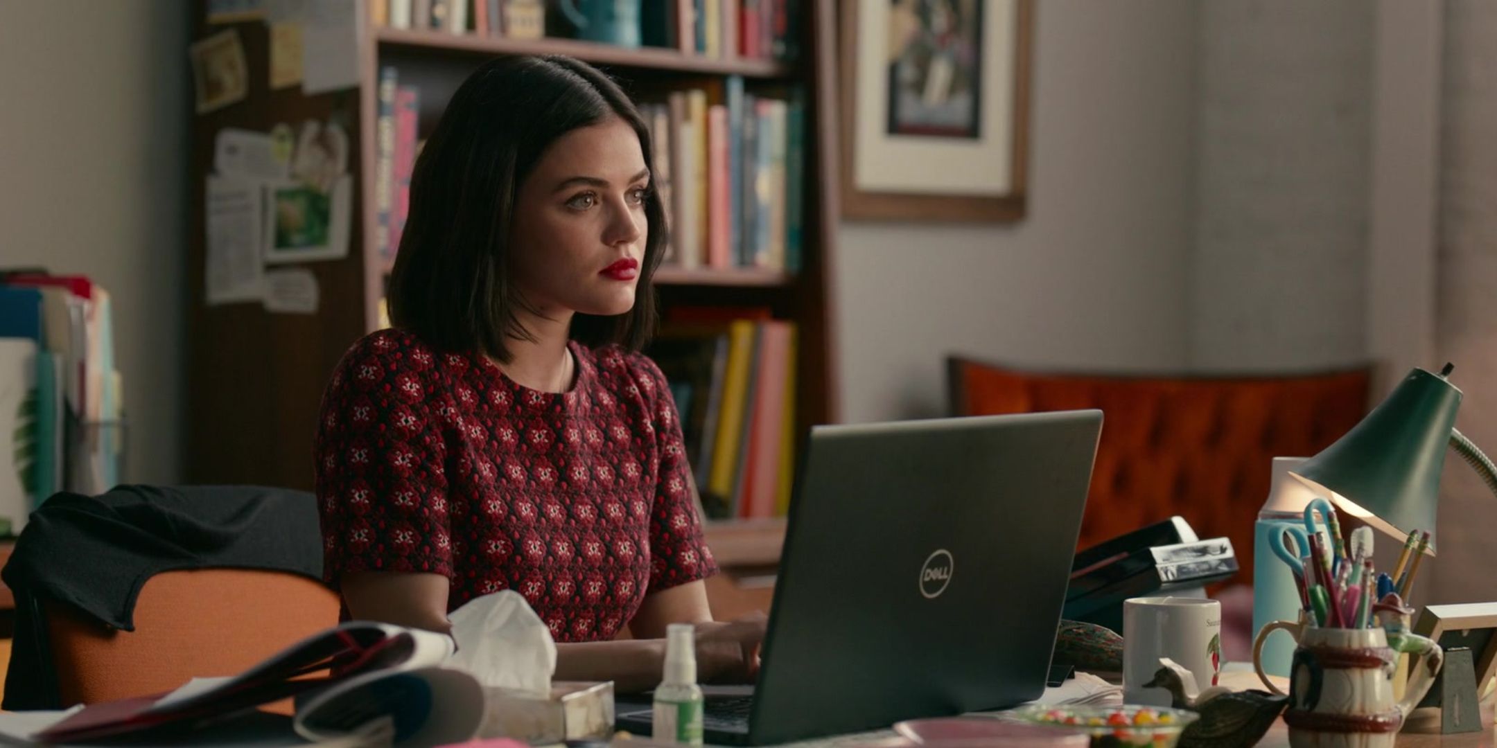 Lucy Hale as Lucy Hutton sitting at her office desk in anger in The Hating Game