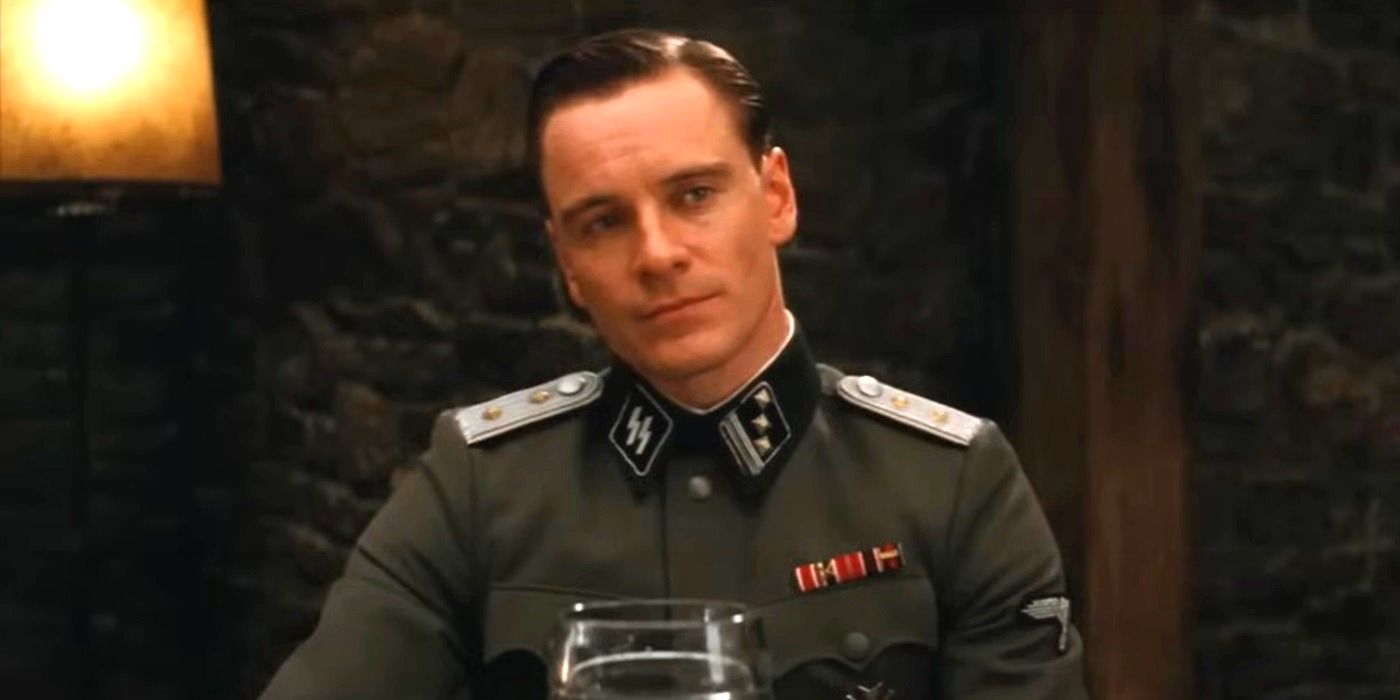 Michael Fassbender looks at a person offscreen cautiously while in a tavern in Inglourious Basterds