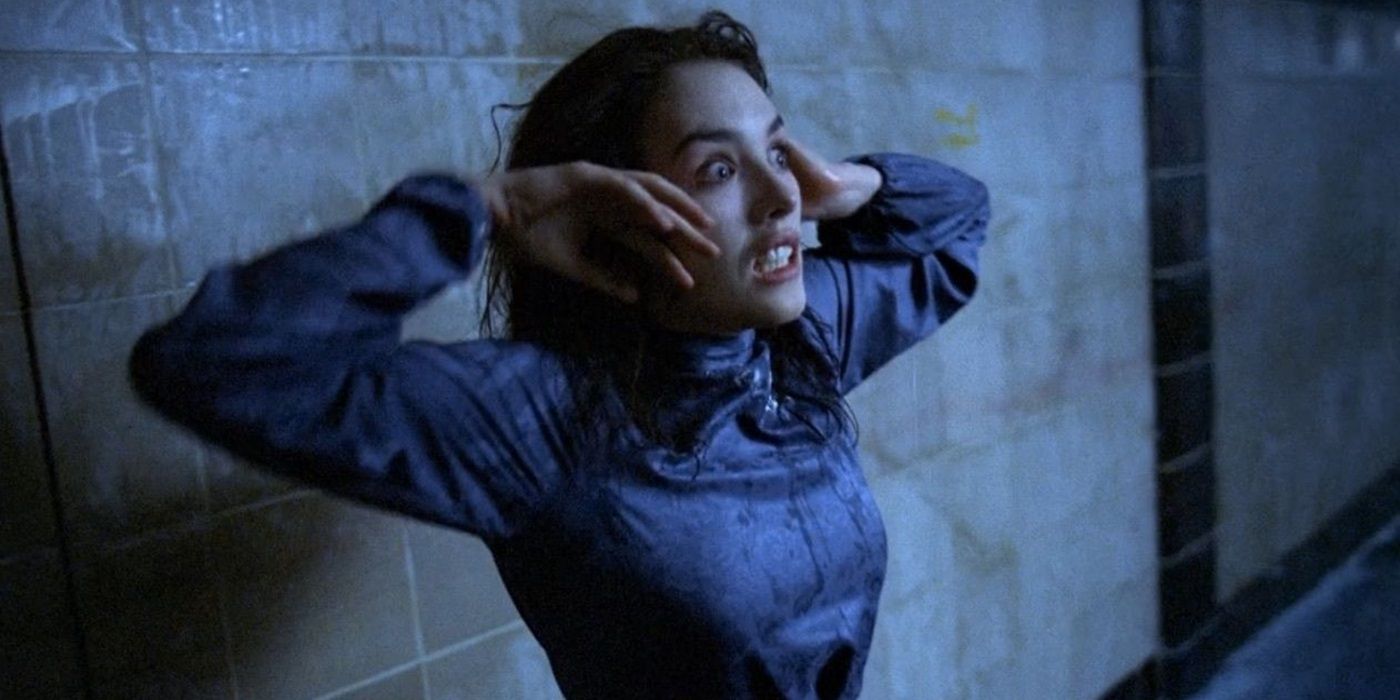 Anna in a blue dress touching her face looking terrified in 1981's Possession