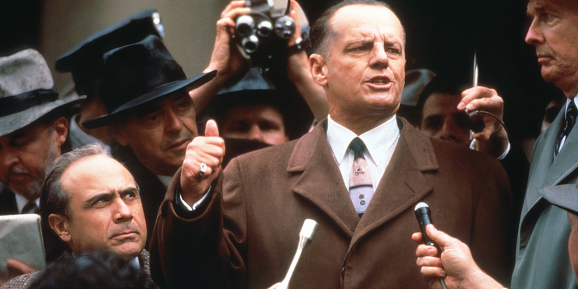 Jack Nicholson talking to a crowd of reporters with Danny DeVito standing beside him in Hoffa (1992)