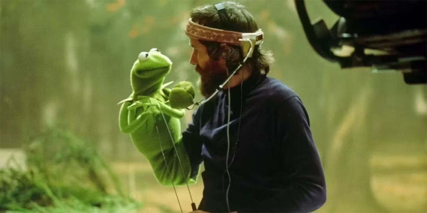 Jim Henson with his mic on controlling a Kermit puppet with a camera filming him