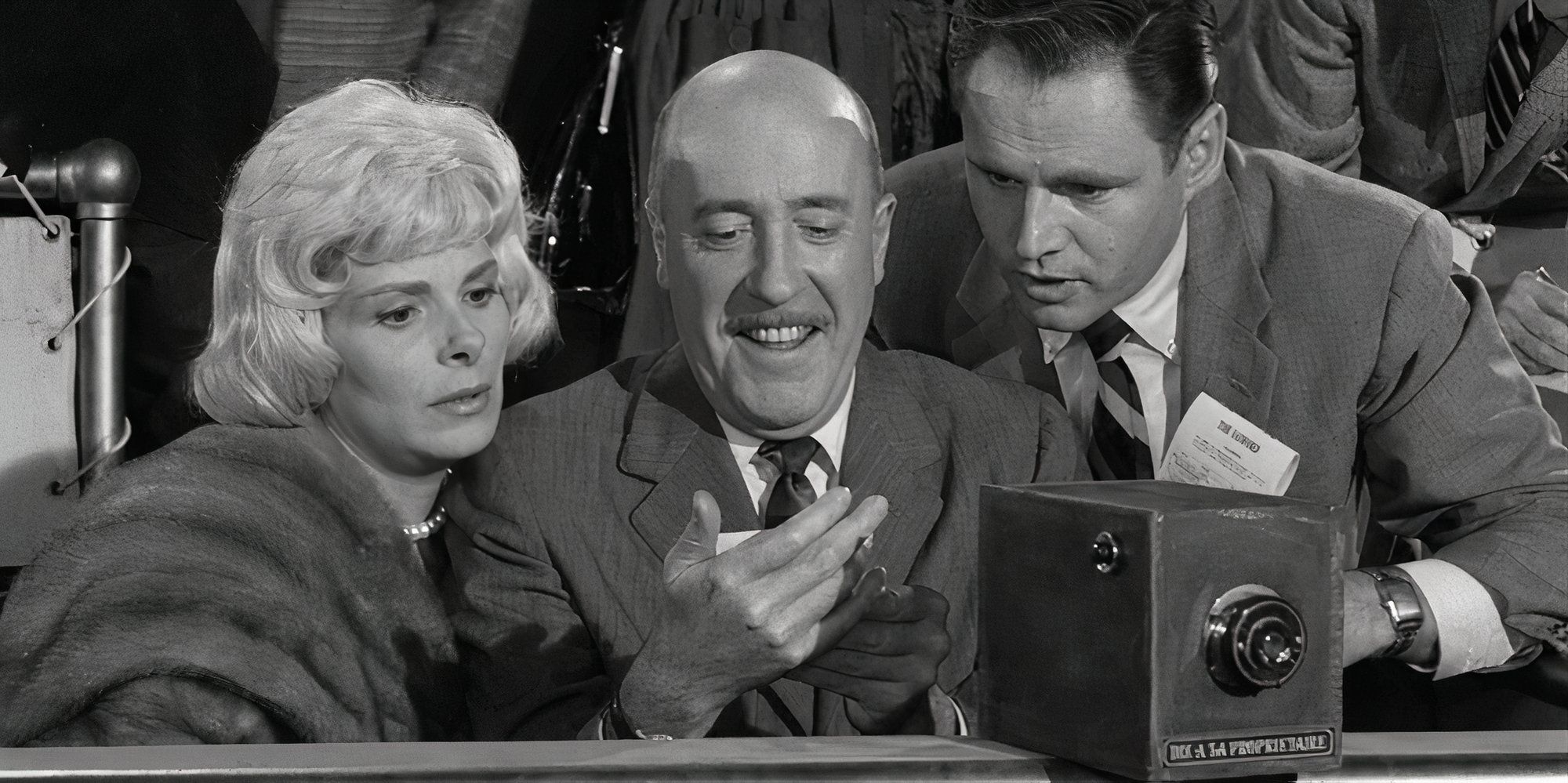 Joan Carson, Fred Clark and Adam Williams all sitting next to each other looking at a photo in Fred Clark's hand in The Twilight Zone