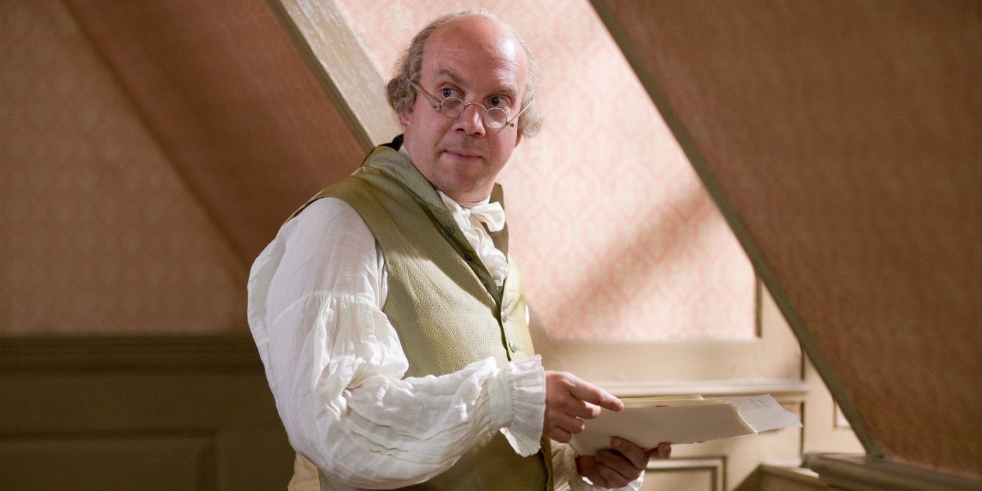 Paul Giamatti glancing up from a handful of papers in HBO's John Adams