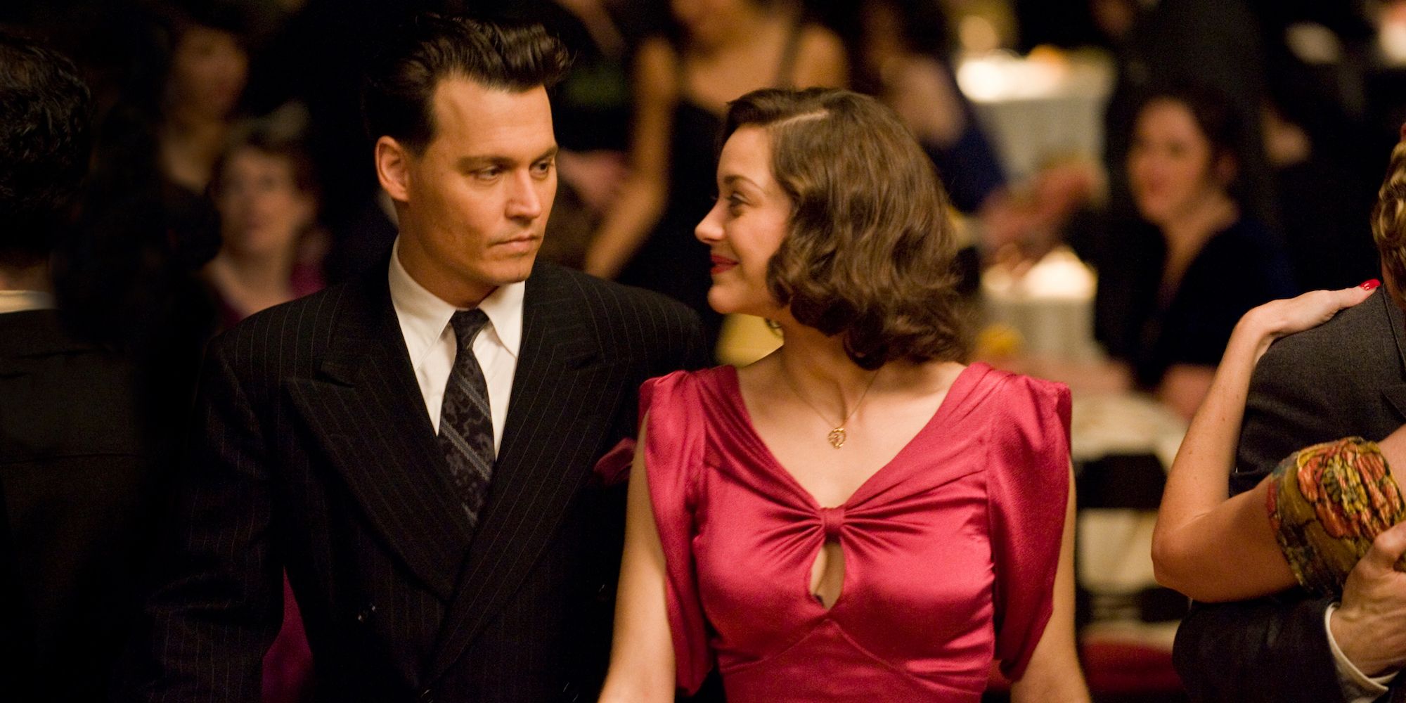 Johnny Depp and Marion Cotillard look at each other on the dance floor in Public Enemies 