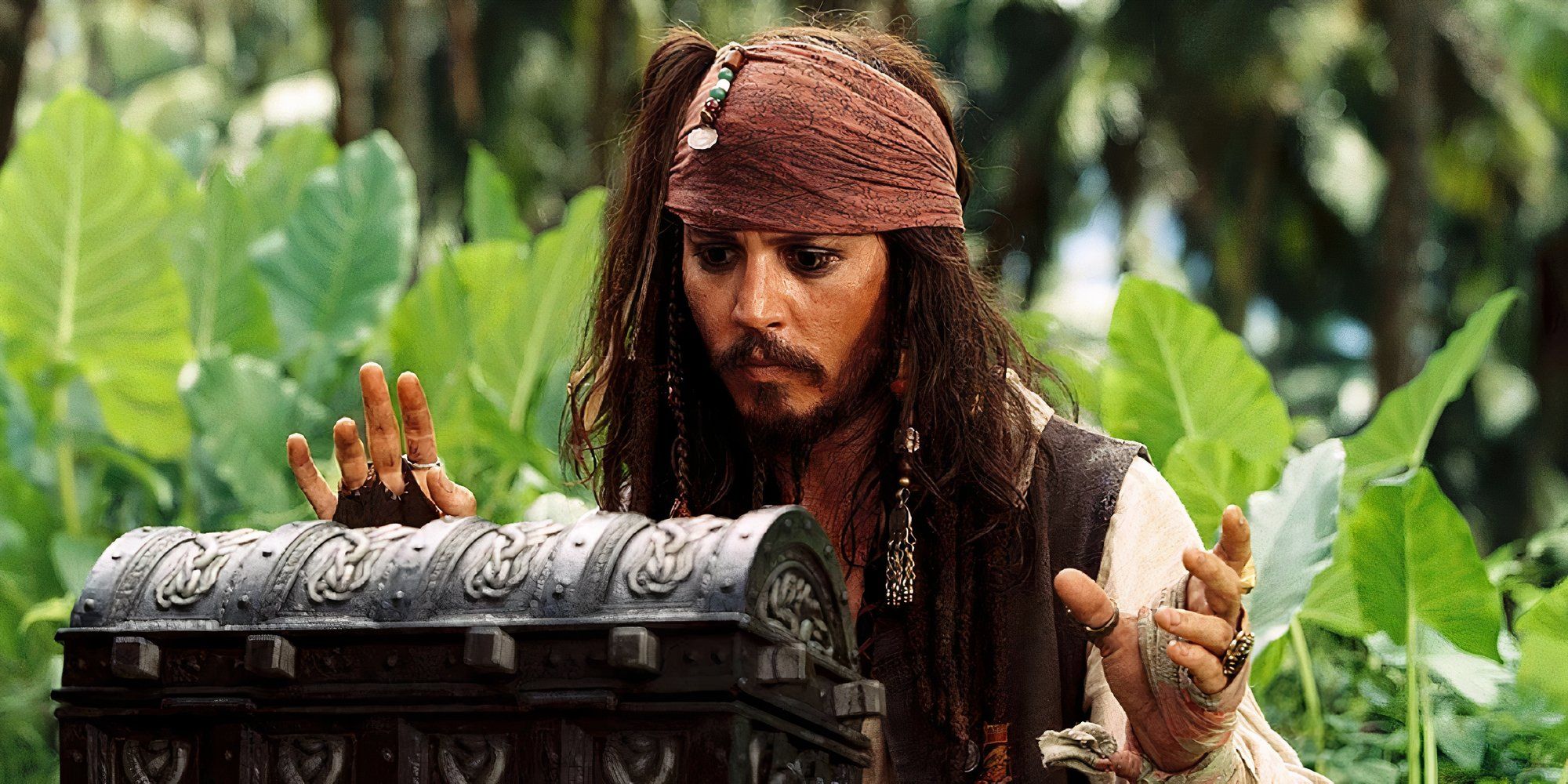 Johnny Depp as Jack Sparrow in Pirates of the Caribbean Dead Man's Chest looking at a treasure box