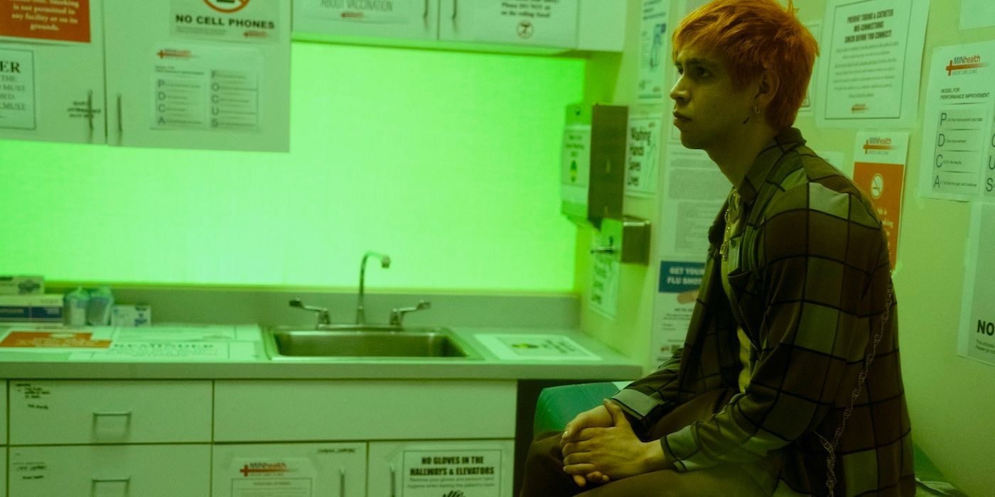Julio Torres sitting in a doctor's office bathed in green light in Fantasmas. 