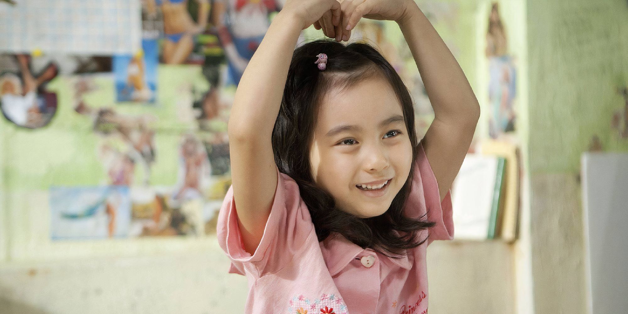 Kal So-won as Ji-young in Miracle in Cell No. 7. making a heart with her arms.