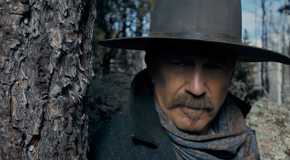 Kevin Costner peeks around a tree in Horizon An American Saga.