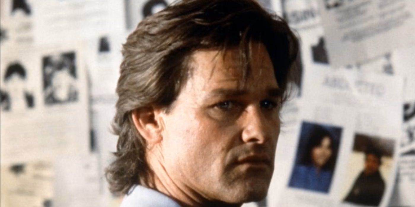 Kurt Russell as Jeff Taylor standing in front of a missing persons board and looking back in Breakdown