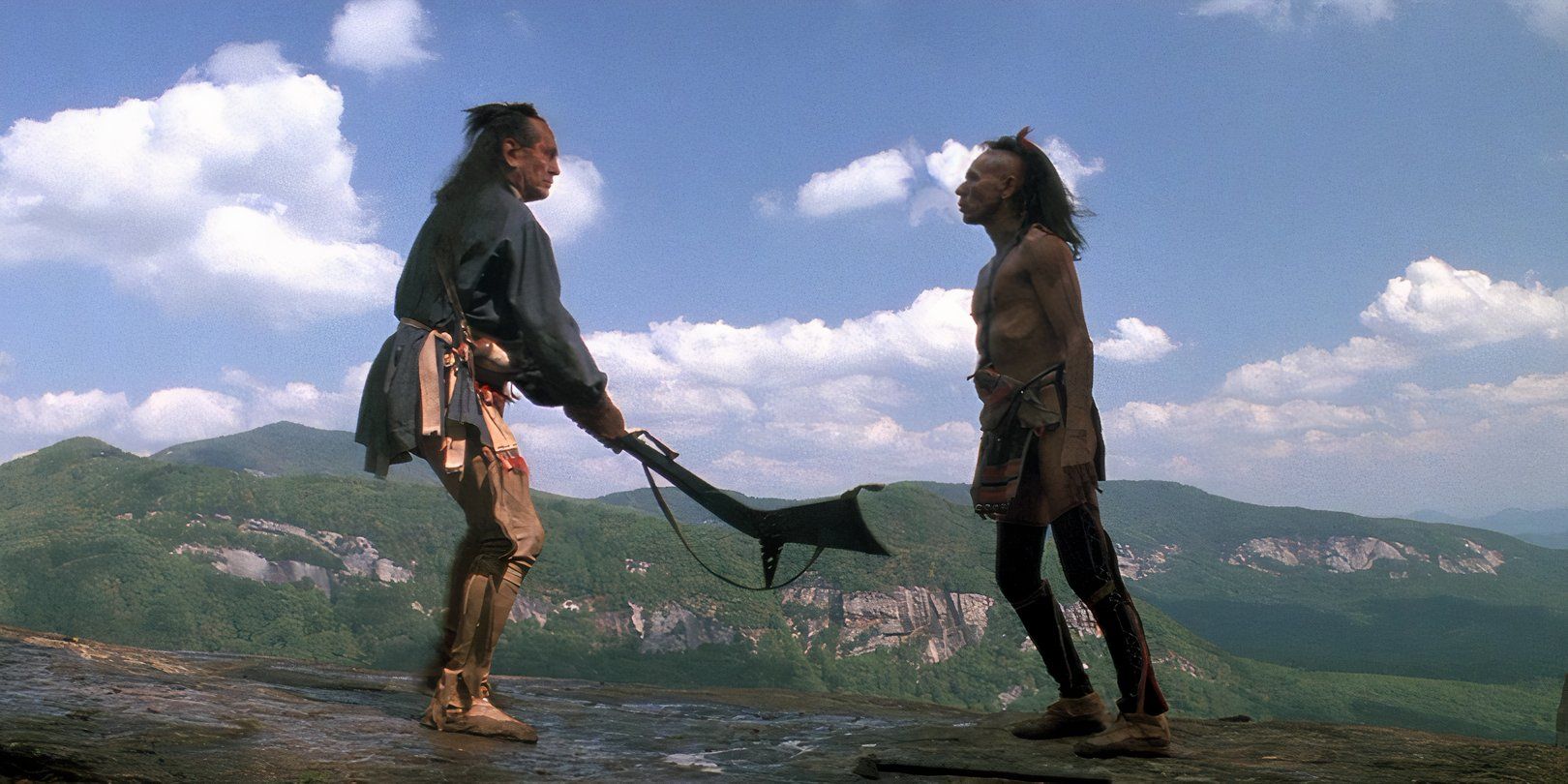 Wes Studi and Russell Means stand off on a cliffside in Michael Mann's 'The Last of the Mohicans'