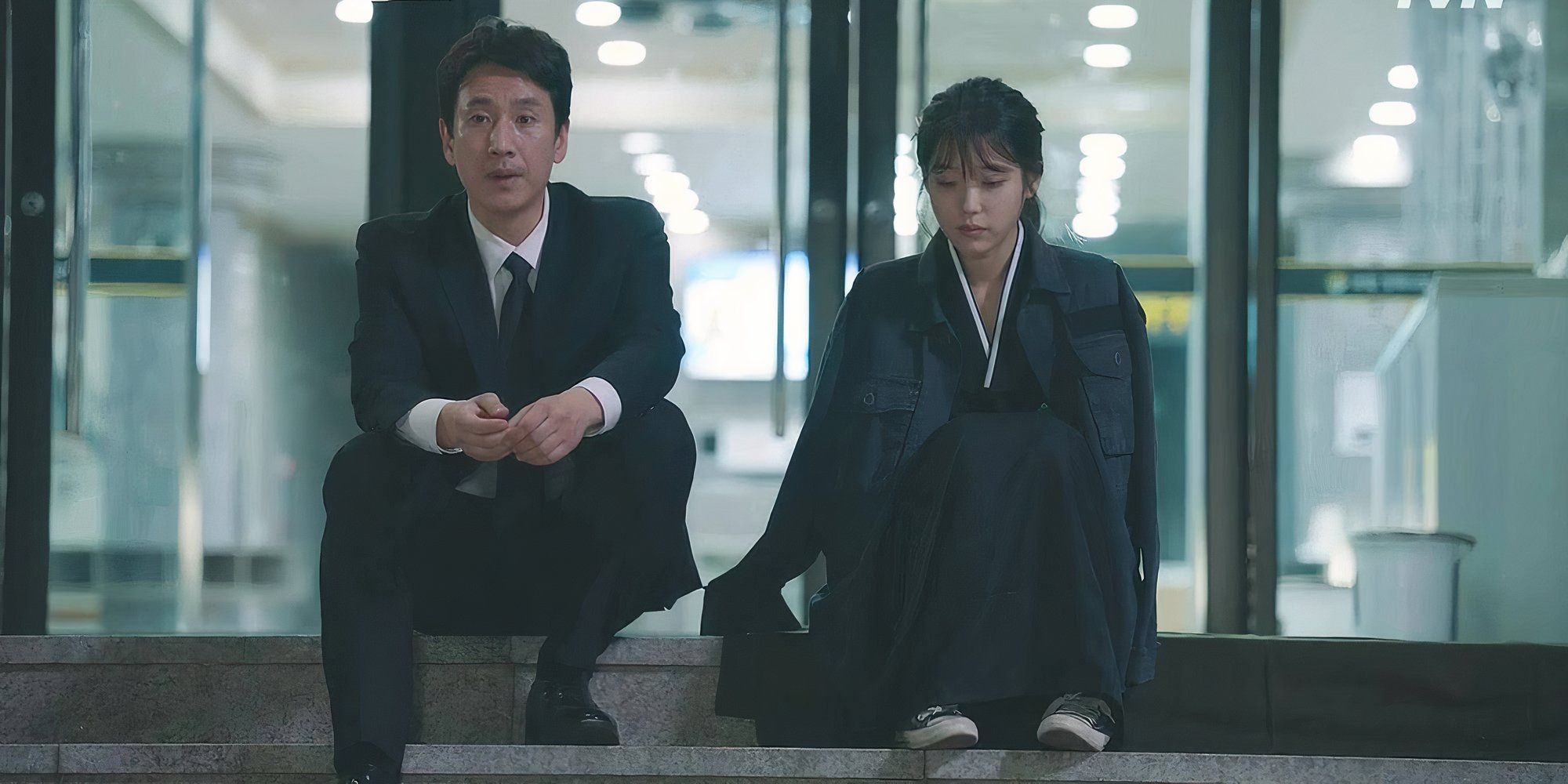 Lee Sun-kyun as Park Dong Hoon and IU as Lee Ji An in My Mister sitting side by side.