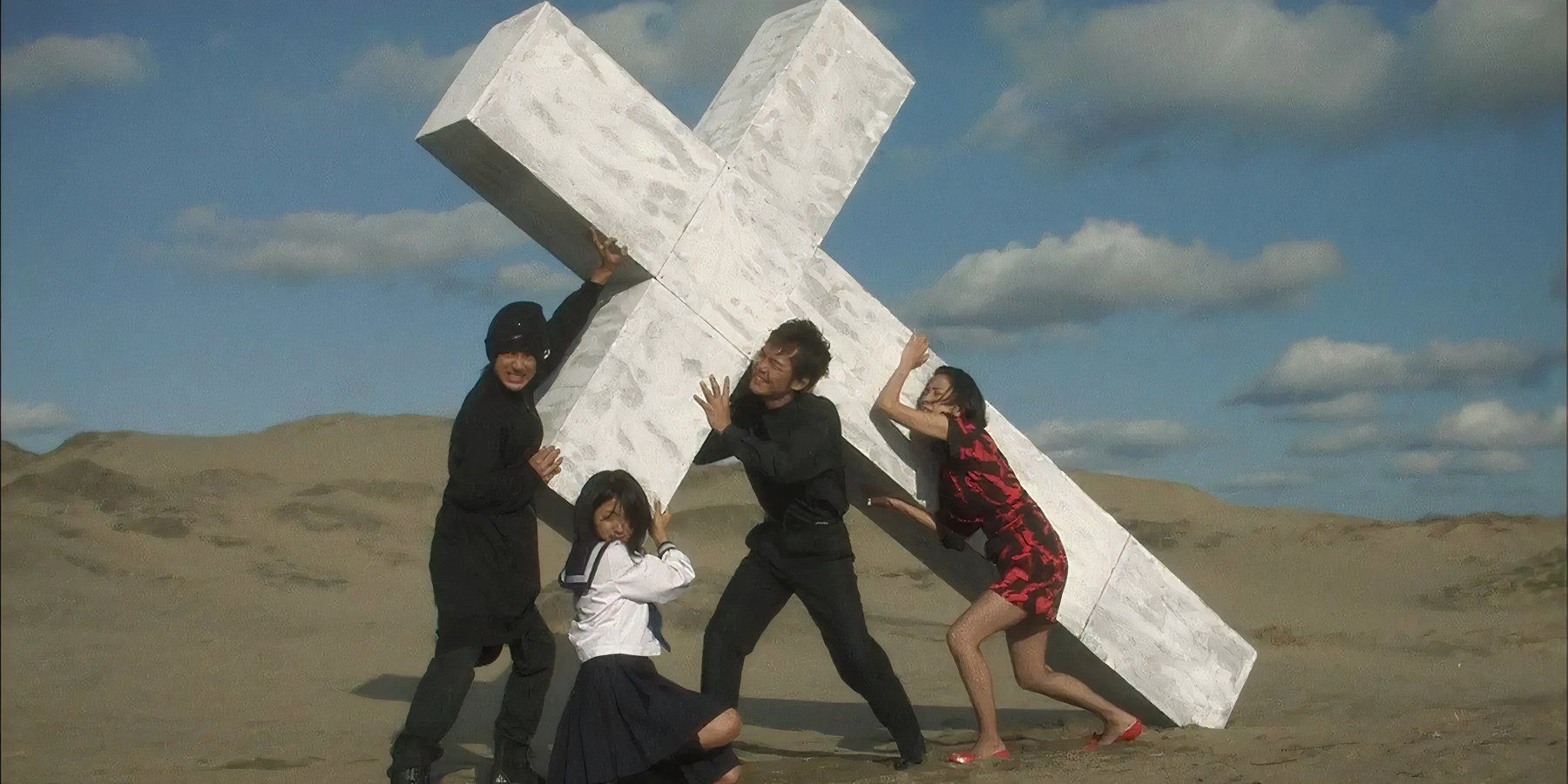 A family carrying a cross in the middle of the desert in &lsquo;Love Exposure&rsquo; (2008)