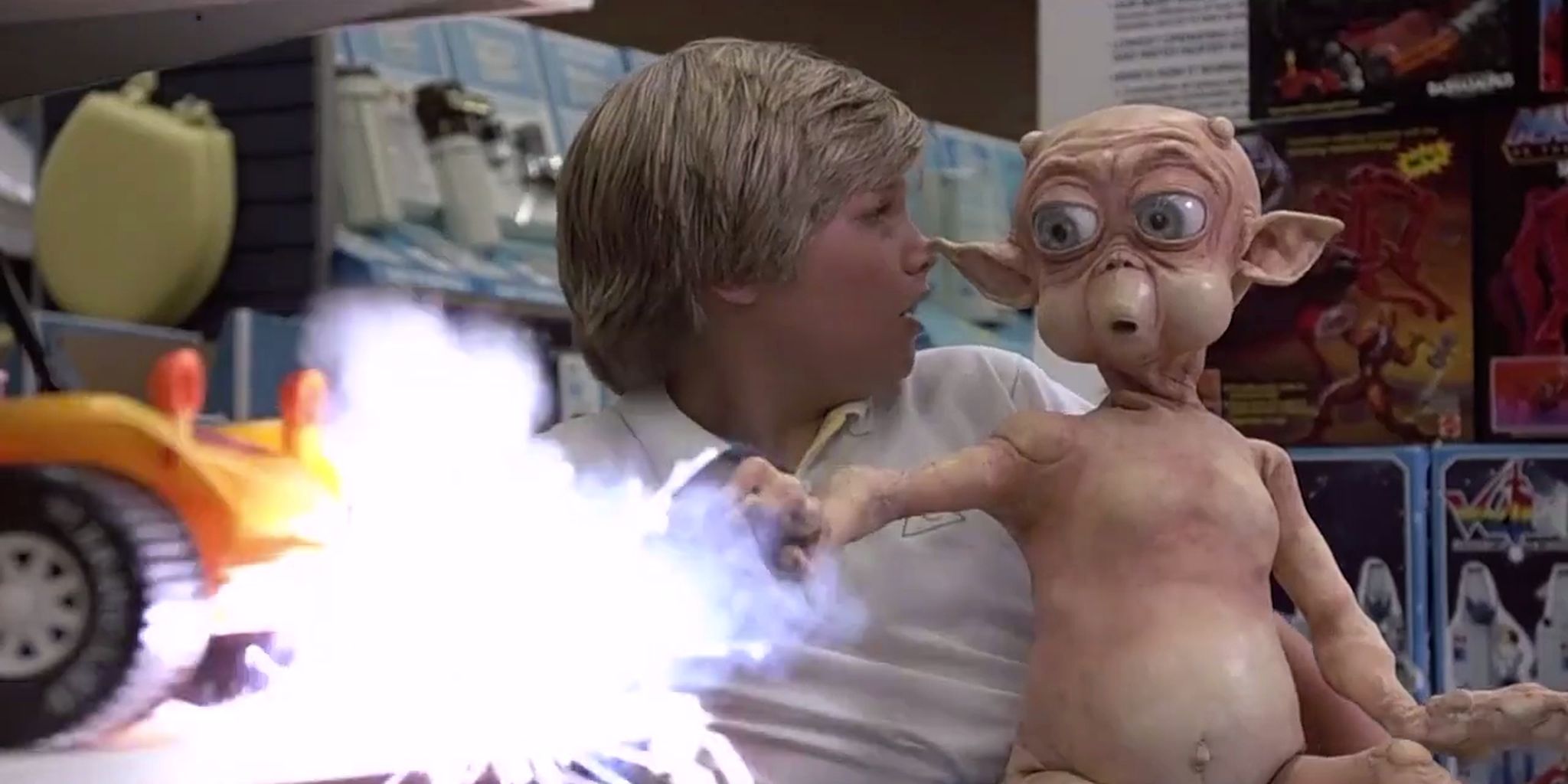 Mac firing an energy blast while sitting in Eric's lap in 'Mac and Me' (1988)