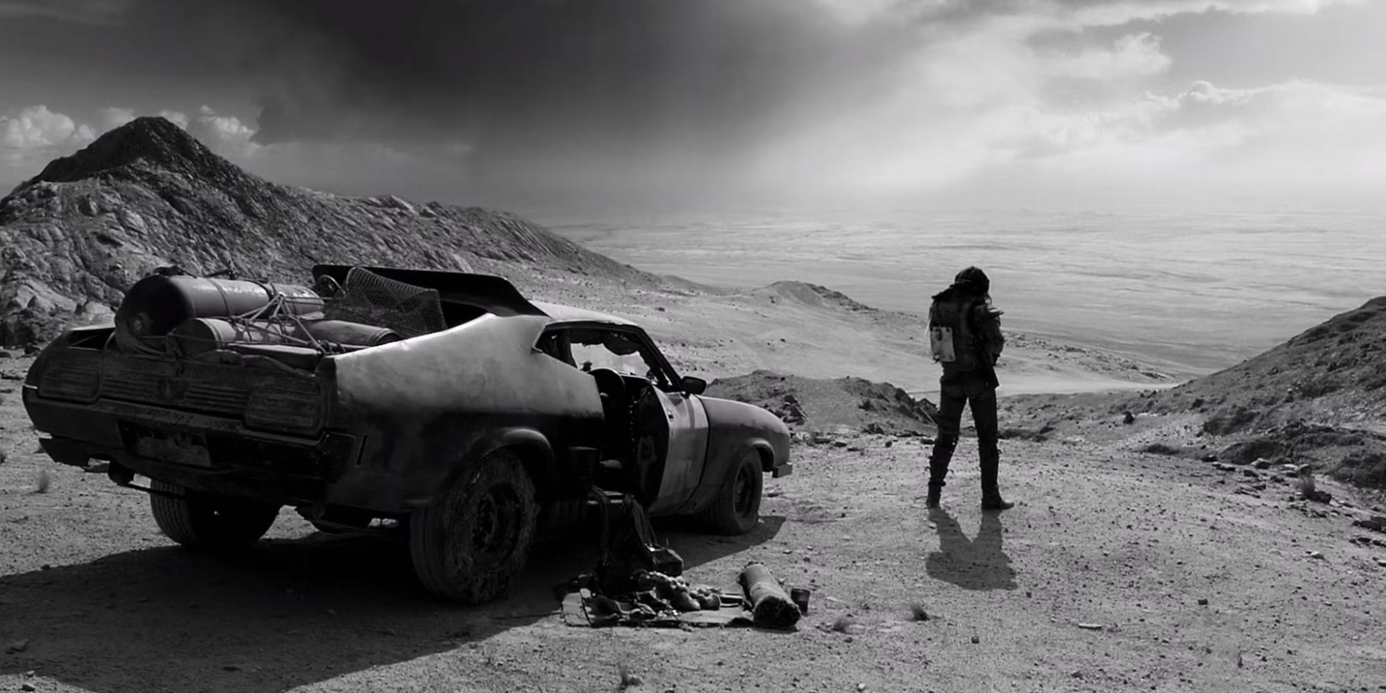 A still of Max standing next to his car in the desert in Fury Road
