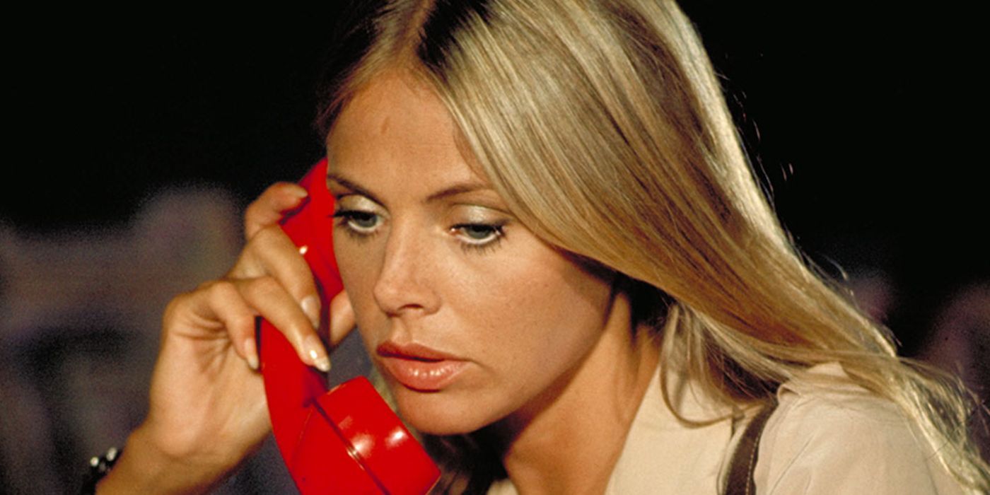 Goodnight (Britt Ekland) holds a red telephone to her ear